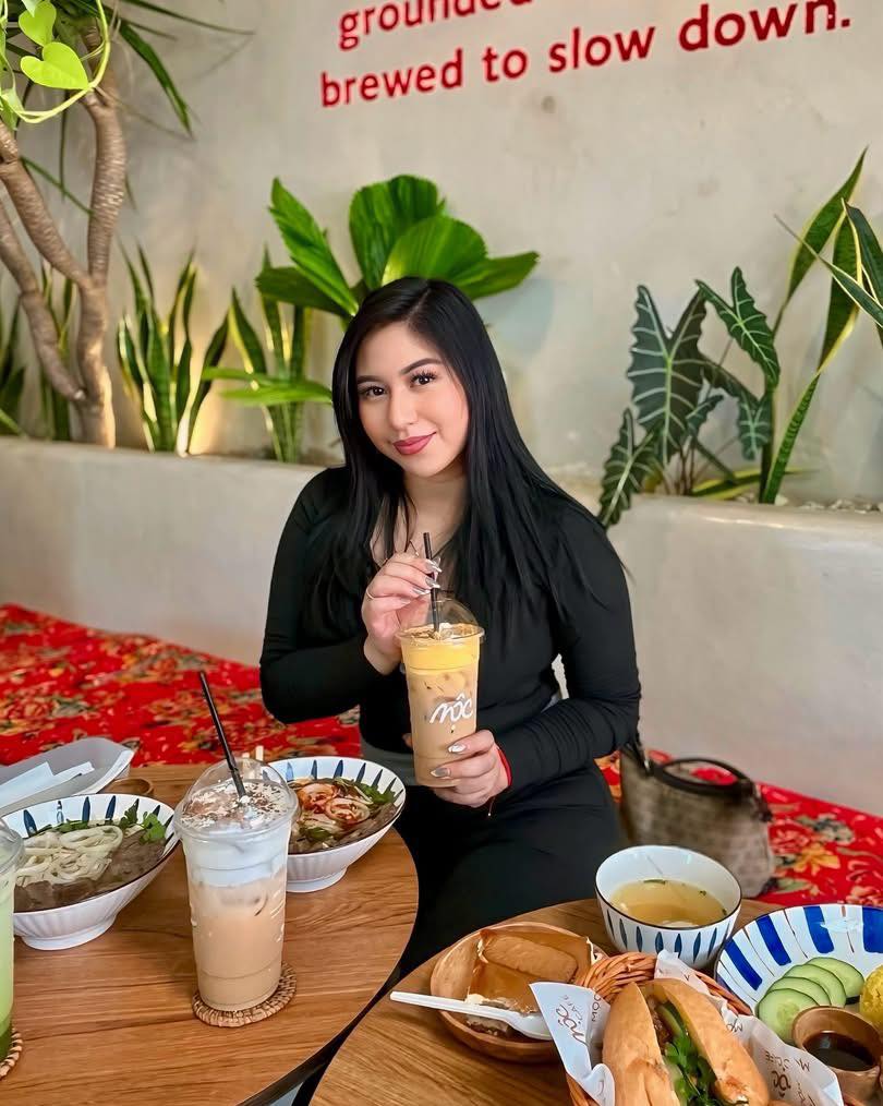 Guest with iced coffee and full food spread