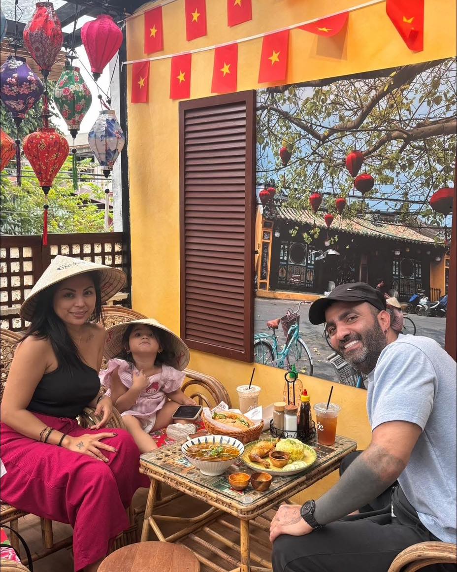 Family seated at MỘC Cafe outdoor area with lanterns