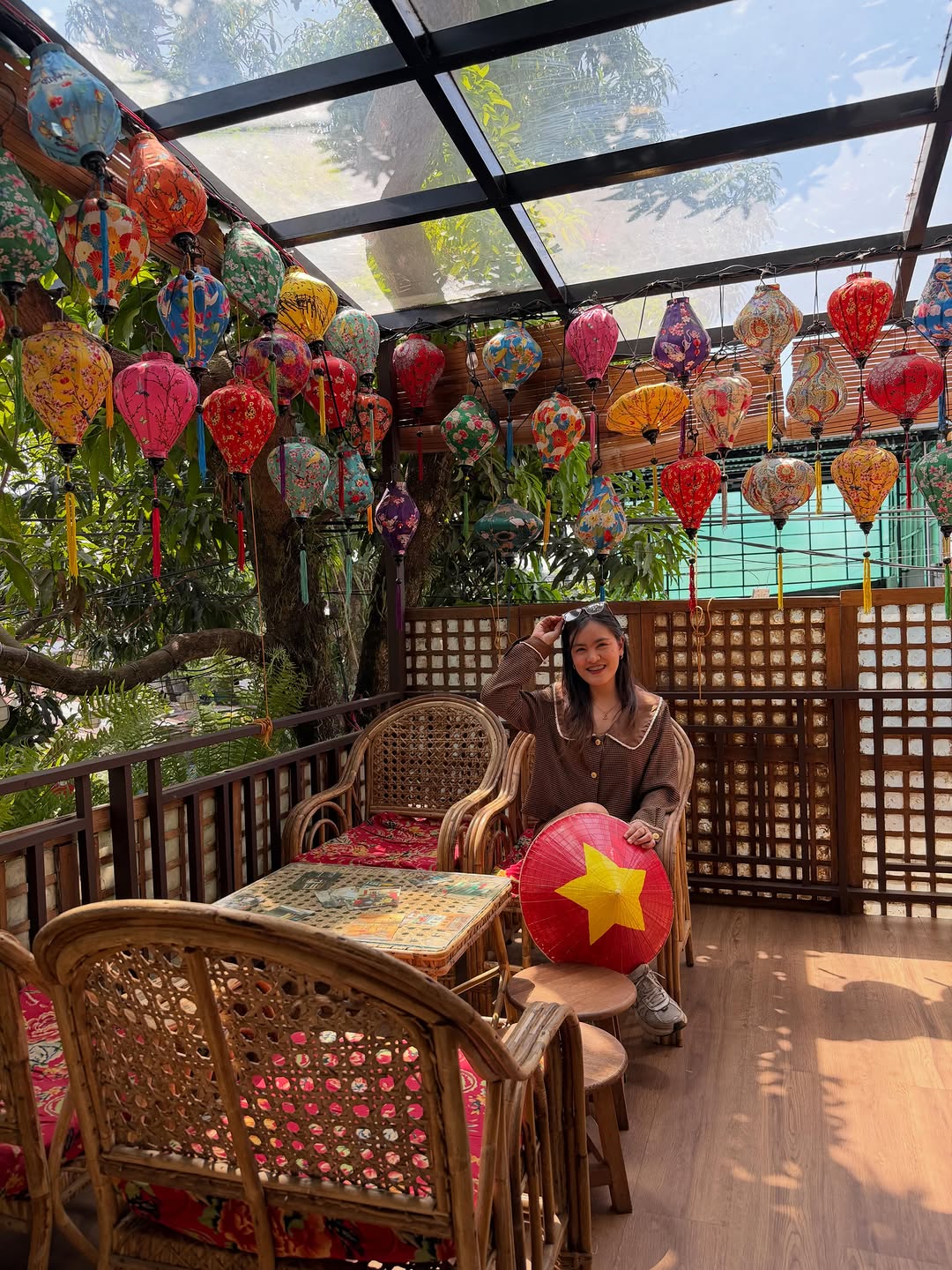 MỘC Cafe staff in uniform against branded mural