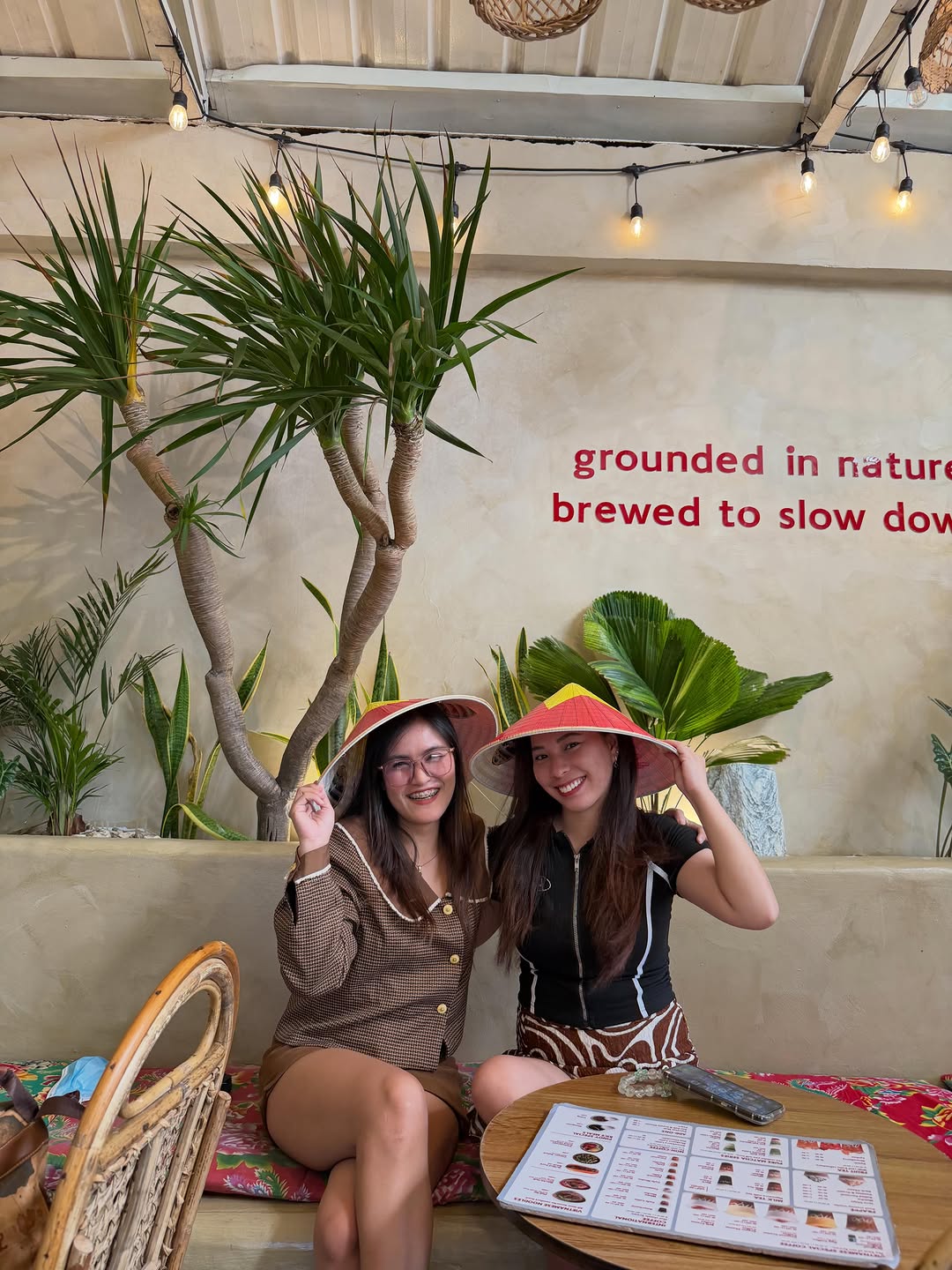 Two guests wearing Vietnamese conical hats at MỘC Cafe